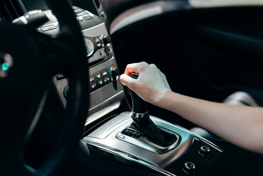 Interior of black car salon. Female hand on transmission